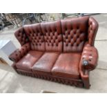 AN OXBLOOD BUTTON-BACK THREE SEATER SETTEE