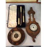 TWO WOODEN BAROMETERS AND A CASED BONE HANDLED MEAT CARVING SET