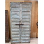 A LARGE PAIR (ATTACHED) MOROCCAN HARDWOOD DOORS WITH METAL BANDING, HANDLES AND BOLT (W:47" H:95")