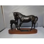 A CERAMIC BESWICK BLACK BEAUTY AND FOAL ON A WOODEN PLINTH