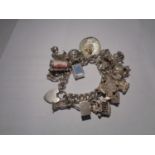 A VINTAGE SILVER CHARM BRACELET WITH TWENTY CHARMS