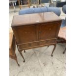 A FIGURED WALNUT COCKTAIL CABINET ON CABRIOLE LEGS