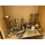 AN ASSORTMENT OF BRASS WARE TO INCLUDE BELLS, CANDLESTICKS AND A HORSE BRASS ETC