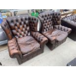 A PAIR OF BROWN BUTTON BACK WINGED EASY CHAIRS