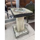 A STONE EFFECT SUN DIAL ON A PEDASTEL BASE