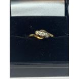 A 9 CARAT GOLD RING ON A TWIST DESIGN WITH THREE IN LINE DIAMONDS IN A PRESENTATION BOX