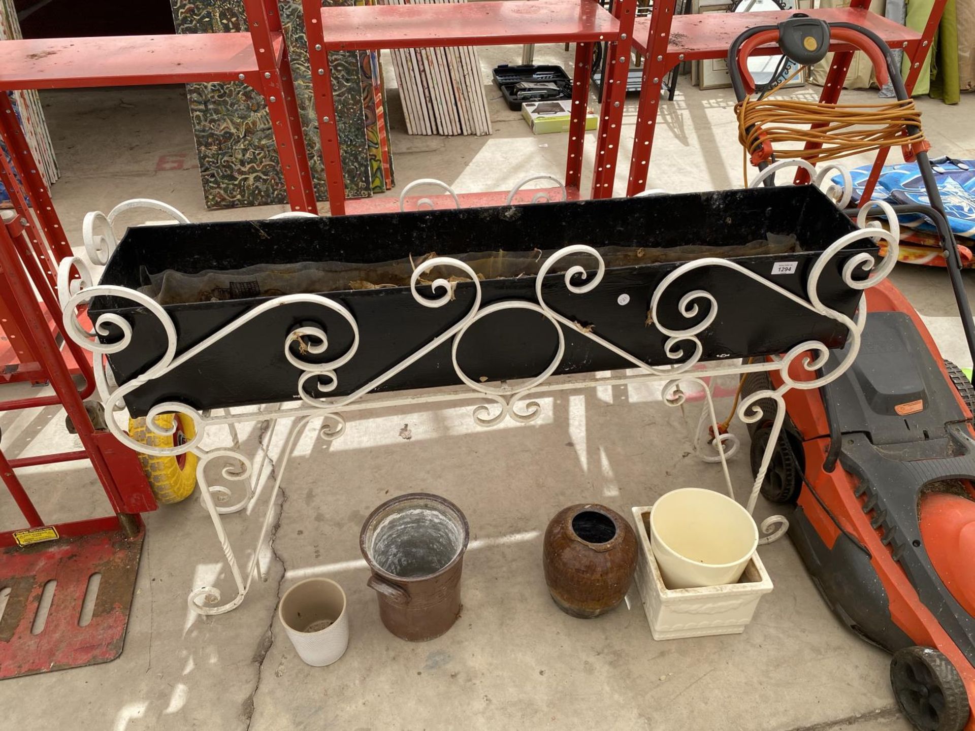 AN ASSORTMENT OF GARDEN PLANTERS TO INCLUDE A TROUGH WITH A DECORATIVE WROUGHT IRON STAND