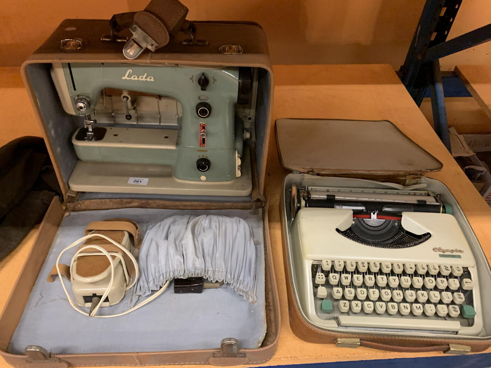 A VINTAGE LADA CASED SEWING MACHINE AND A VINTAGE CASED OLYMPIA SPLENDID 33 TYPEWRITER