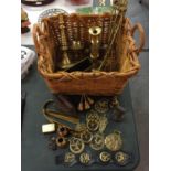 A WICKER LOG BASKET WITH BRASS CONTENTS TO INCLUDE BRASS FINIALS, TOASTING FORKS ETC