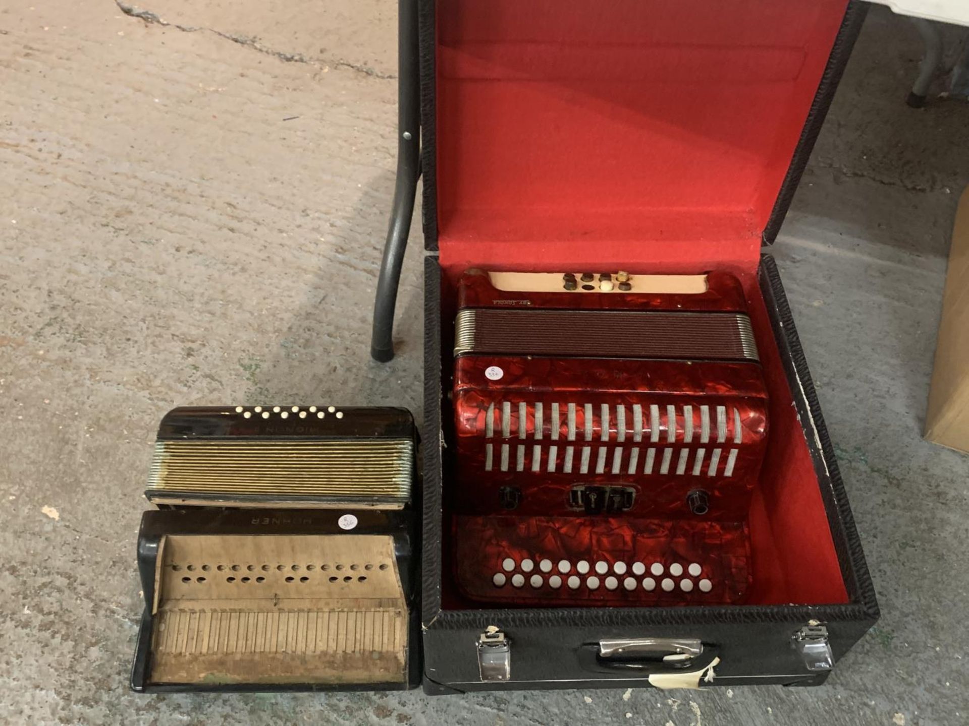 AN ACCORDIAN BY SONOLA IN A CASE AND A SMALLER ONE FOR REPAIR