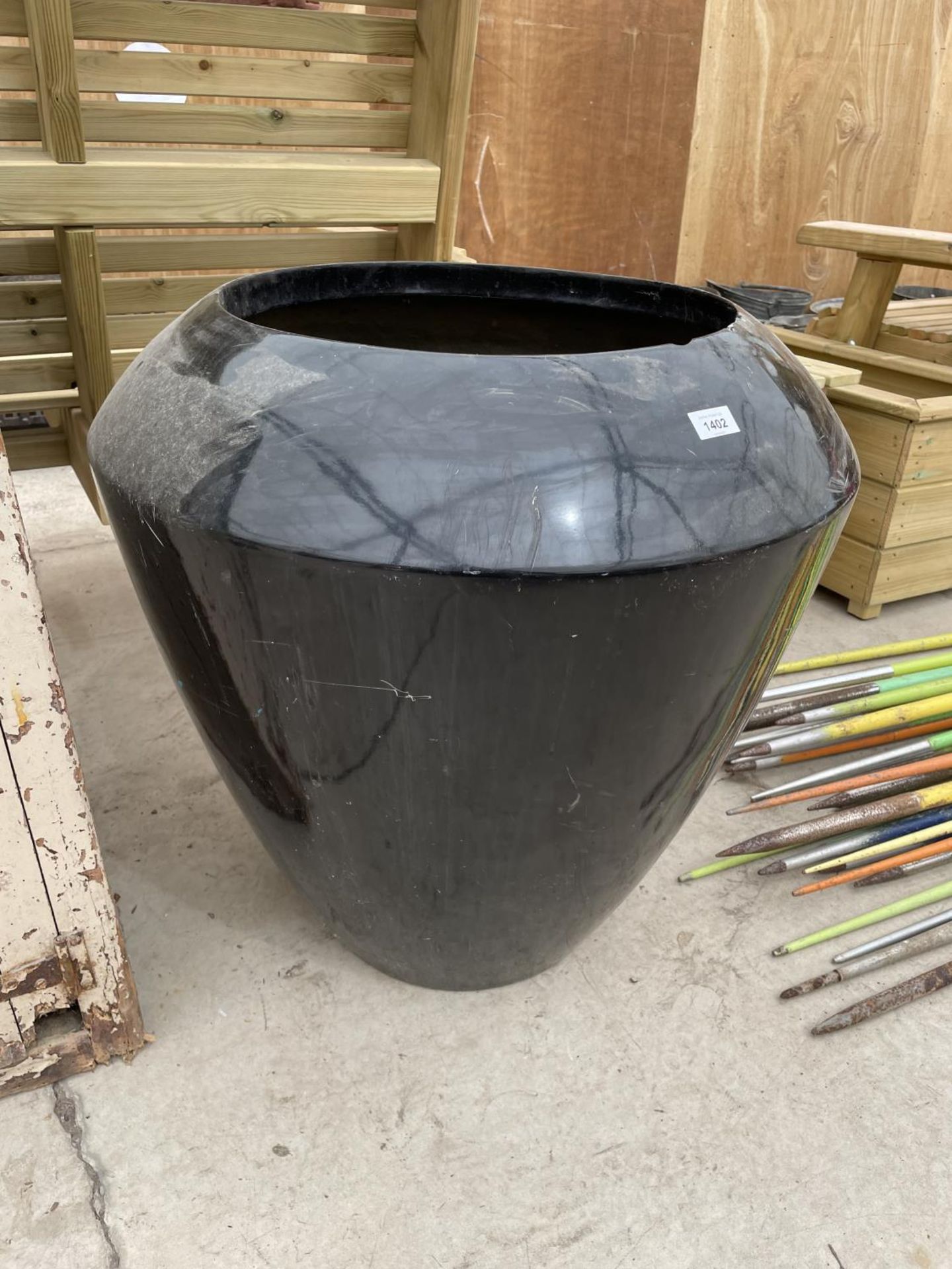 A LARGE STYLISH BLACK FIBRE GLASS URN PLANTER