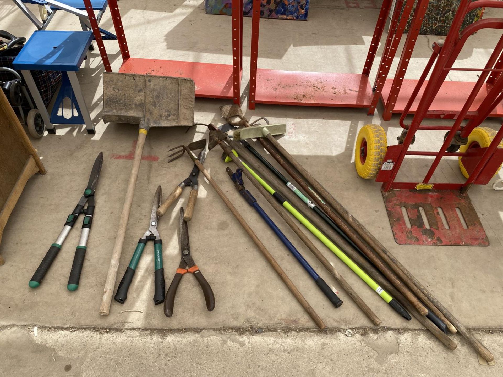 AN ASSORTMENT OF GARDEN TOOLS TO INCLUDE A BRICK HOD, SHEARS AND HOES ETC