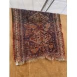 A RED PATTERNED PERSIAN STYLE FRINGED RUG