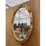 A DECORATIVE GILT FRAMED OVAL MIRROR