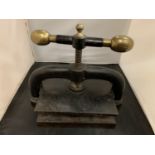 A VINTAGE CAST IRON BOOK PRESS WITH BRASS KNOB TURNING HANDLE