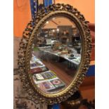 AN OVAL GILT FRAMED MIRROR, APPROX 62CM X 47CM