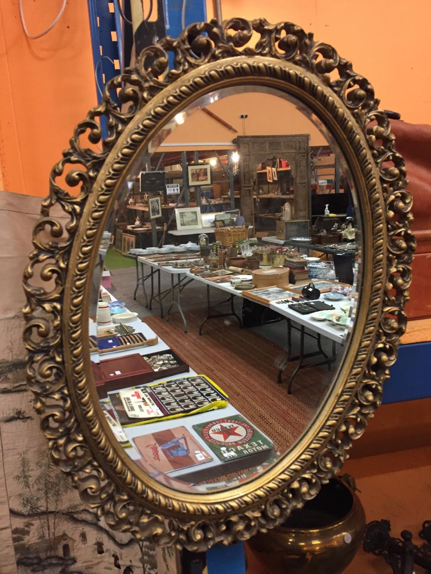 AN OVAL GILT FRAMED MIRROR, APPROX 62CM X 47CM