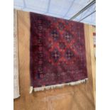 A RED AFGAN FRINGED RUG