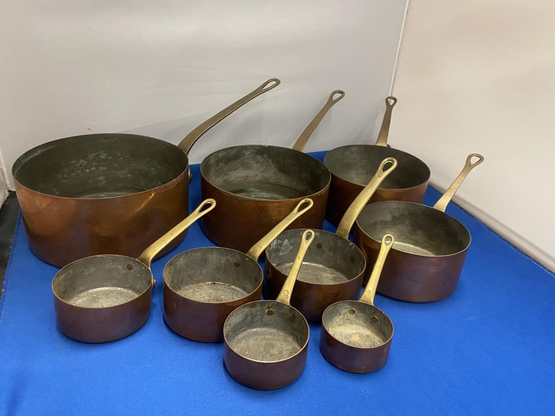A SET OF NINE COPPER GRADUATED PANS WITH BRASS HANDLES - Image 2 of 3