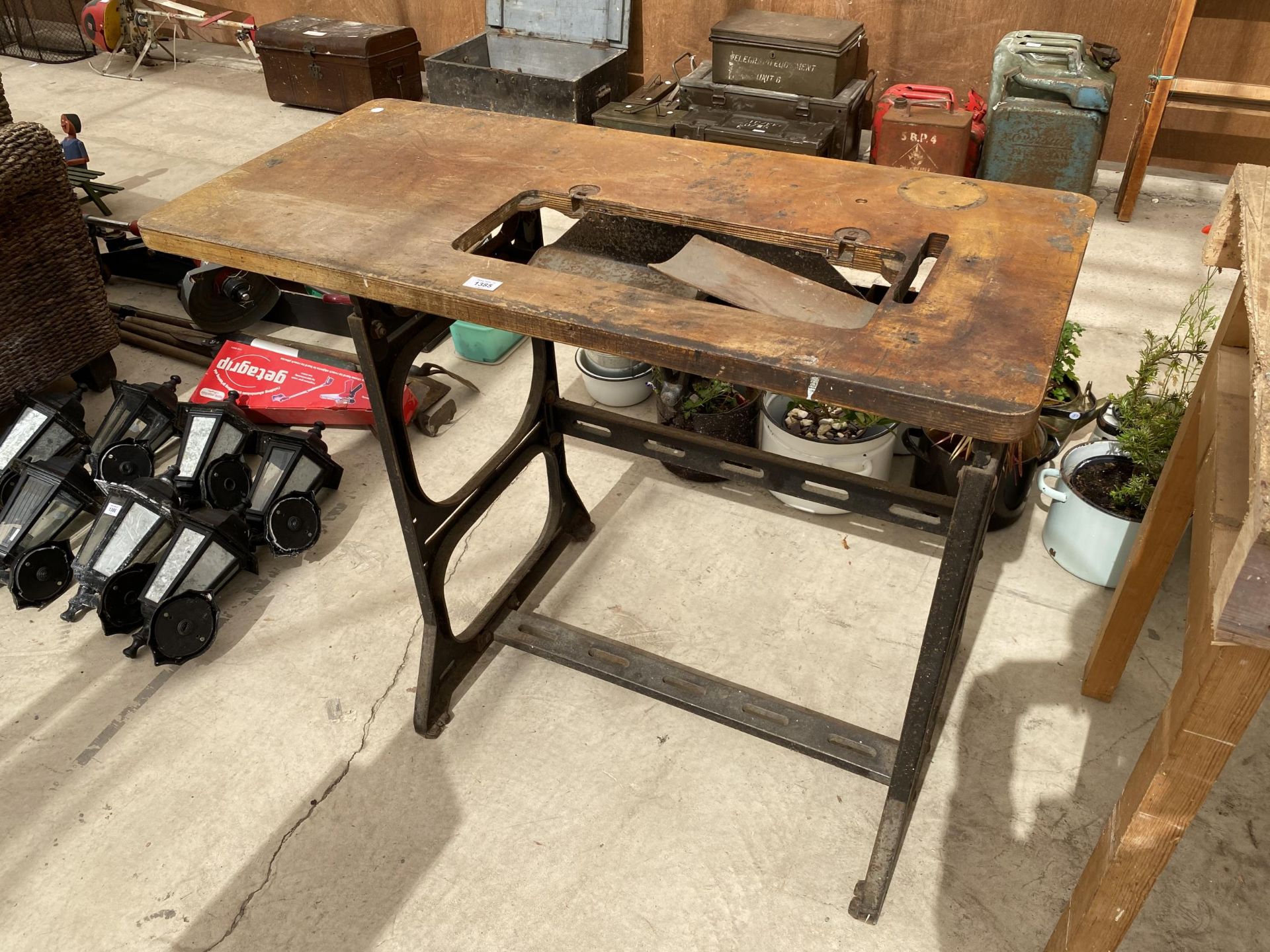 AN INDUSTRIAL SEWING MACHINE TABLE WITH HEAVY CAST IRON BASE