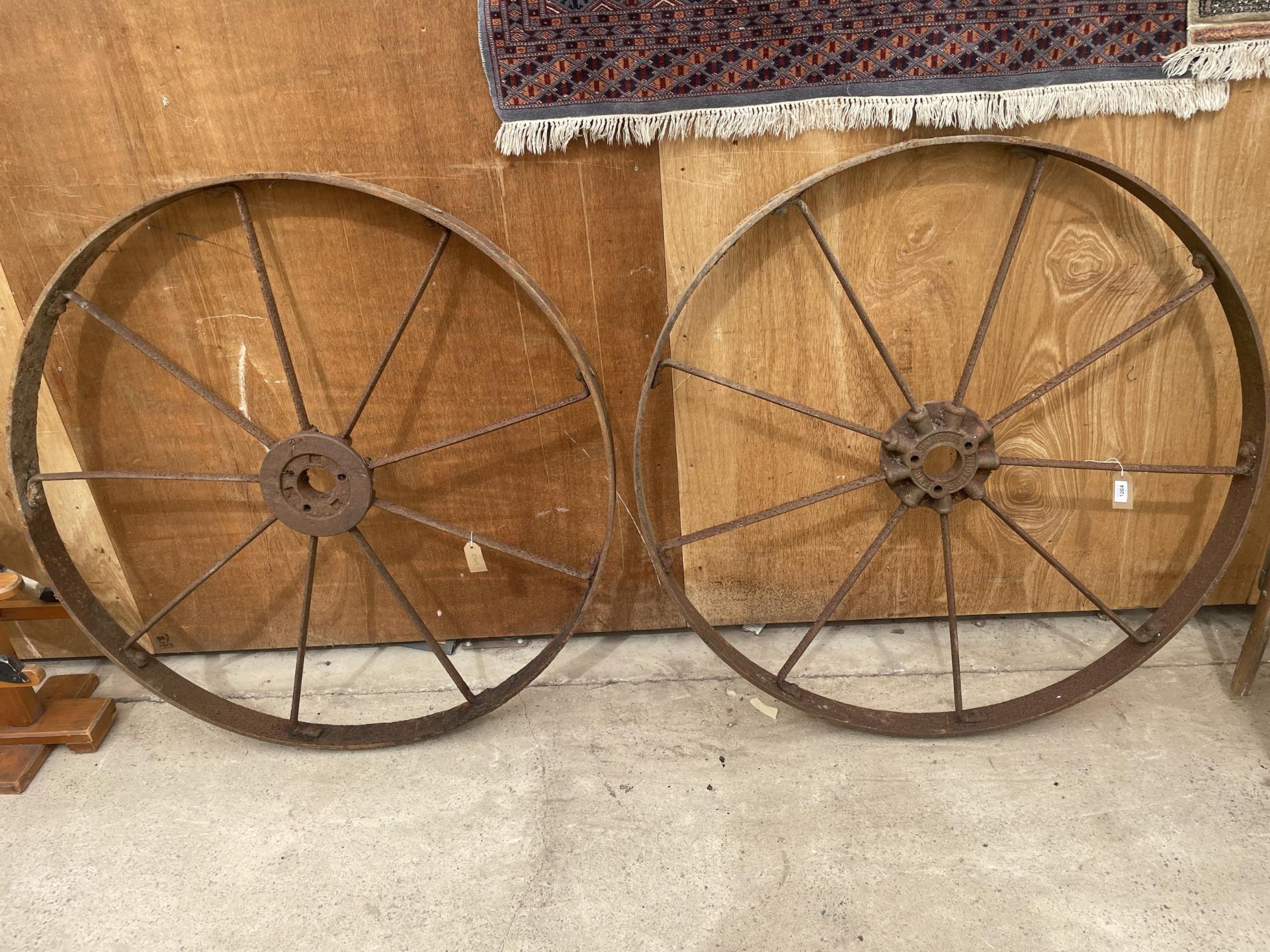 A PAIR OF CAST IRON CART WHEELS WITH NINE SPOKES, STAMPED 'BAMFORDS UTTOXETER'