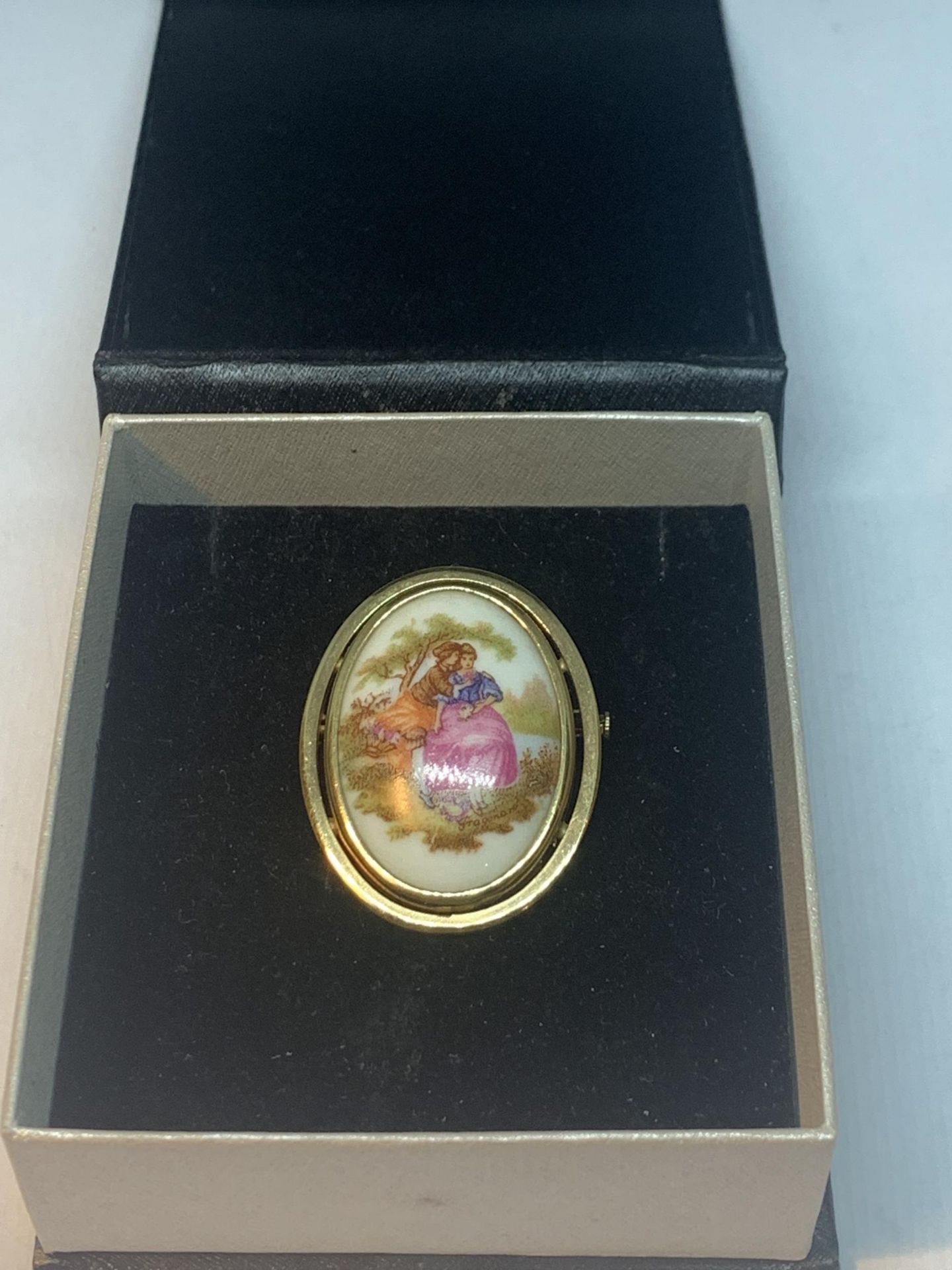 A YELLOW METAL BROOCH WITH A LIMOGES CERAMIC PLAQUE IN A PRESENTATION BOX