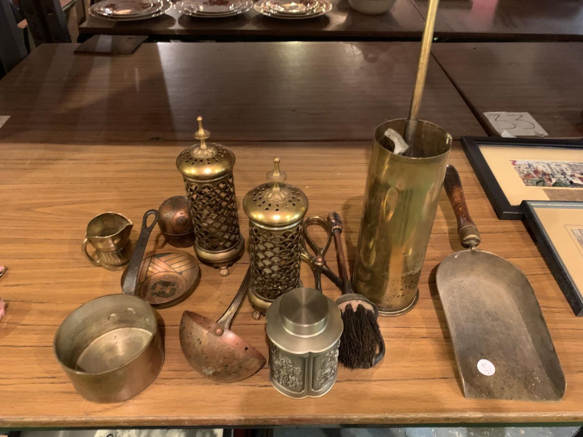 A COLLECTION OF BRASS WARE TO INCLUDE A TRENCH SHELL, DECORATIVE LANTERNS, PAN, LADLE ETC
