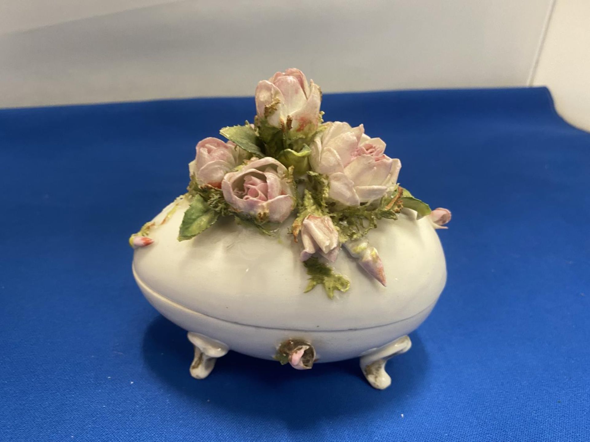 A DELICATE PORCELAIN EGG SHAPED LIDDED TRINKET DISH ON THREE FEET WITH FLOWER DETAILING, MARKED TO