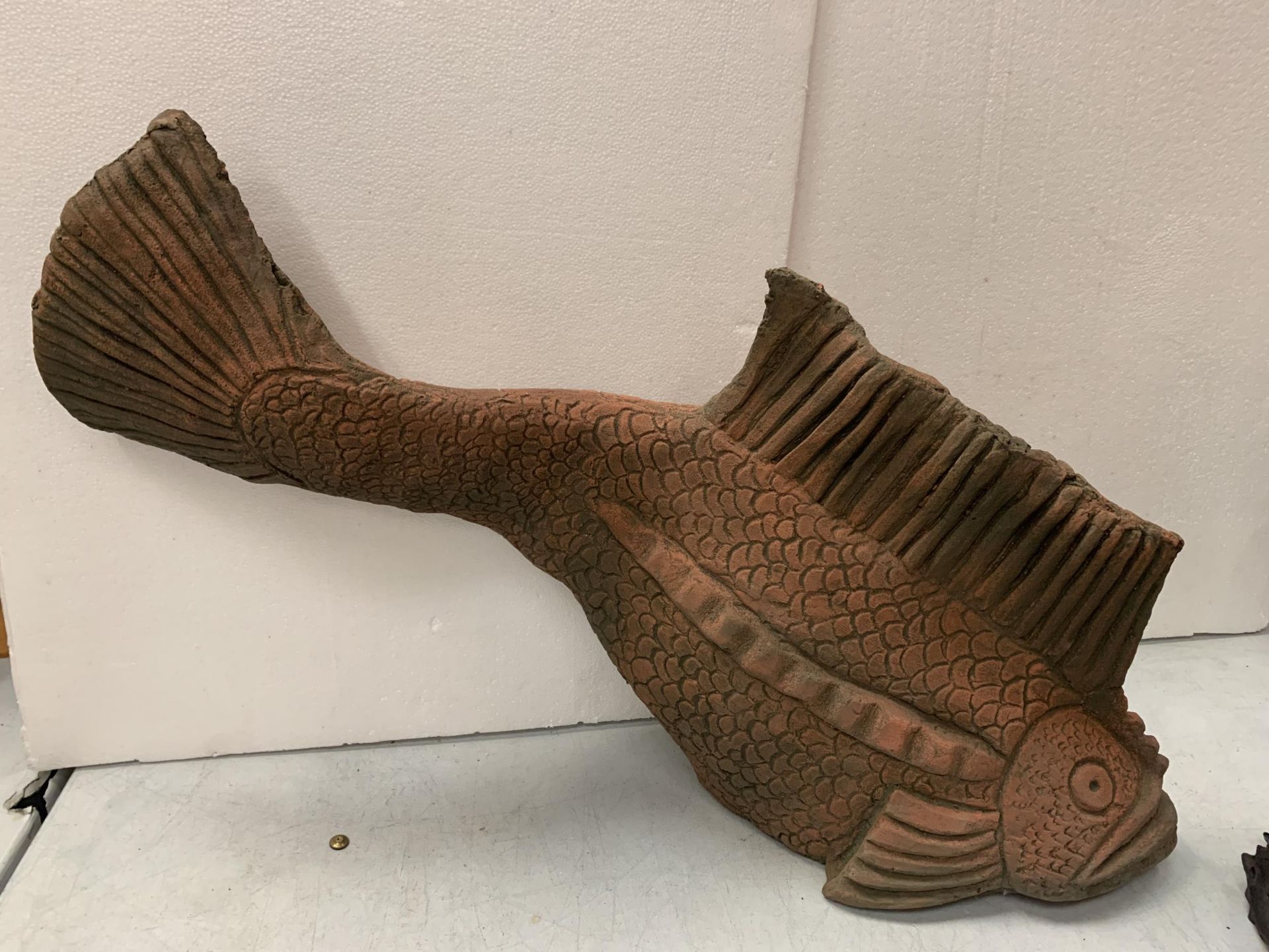 A LARGE TERRACOTTA STONE FISH, APPROX LENGTH 78CM, HEIGHT 48CM