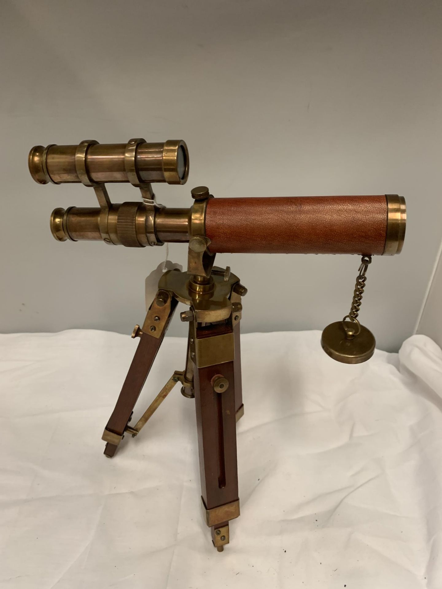 A BRASS, WOOD AND LEATHER TELESCOPE ON TRIPOD STAND