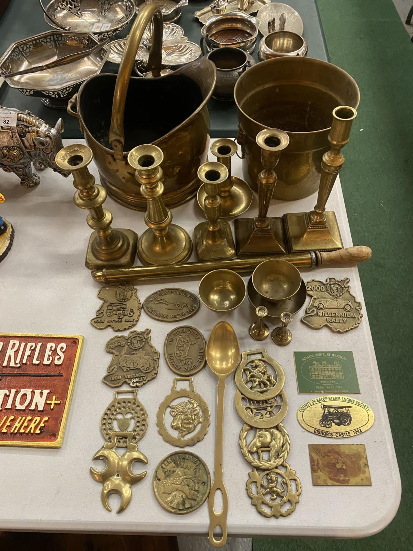 A COLLECTION OF BRASS WARE TO INCLUDE COAL SCUTTLE, CANDLESTICKS, HORSE BRASSES, RALLY PLAQUES ETC