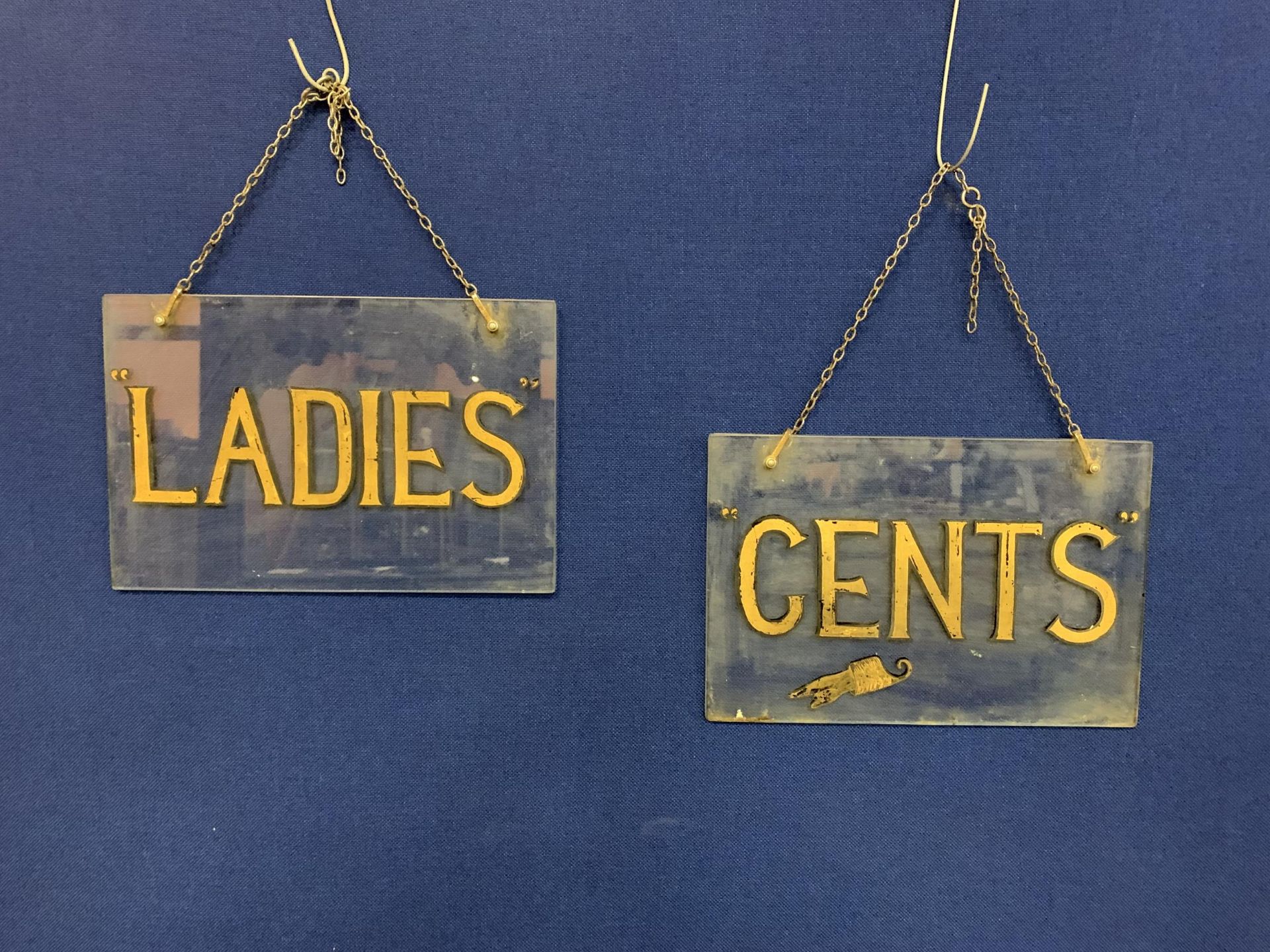 A PAIR OF EARLY 20TH CENTURY, HAND PAINTED ON GLASS, 'LADIES & GENTS' LAVATORY SIGNS 38CM X 25CM