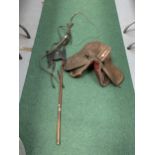 A SMALL VINTAGE DRESSAGE SADDLE, A BRIDLE WITH BLINKERS AND A LONG WHIP