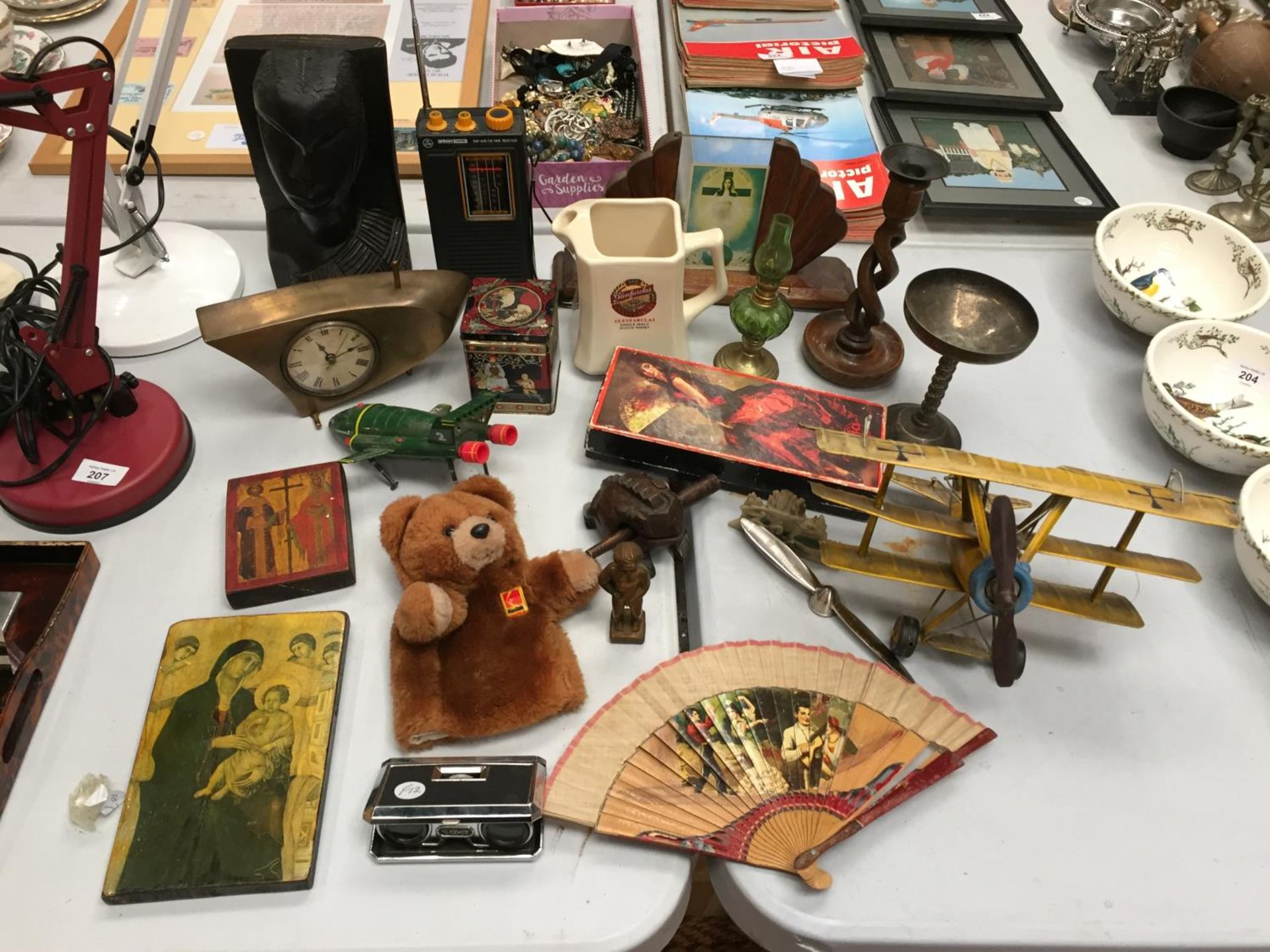 A MIXED LOT TO INCLUDE A CARVED TRIBAL FIGURE, RELIGIOUS PLAQUES, A TIN AEROPLANE AND FURTHER ITEMS