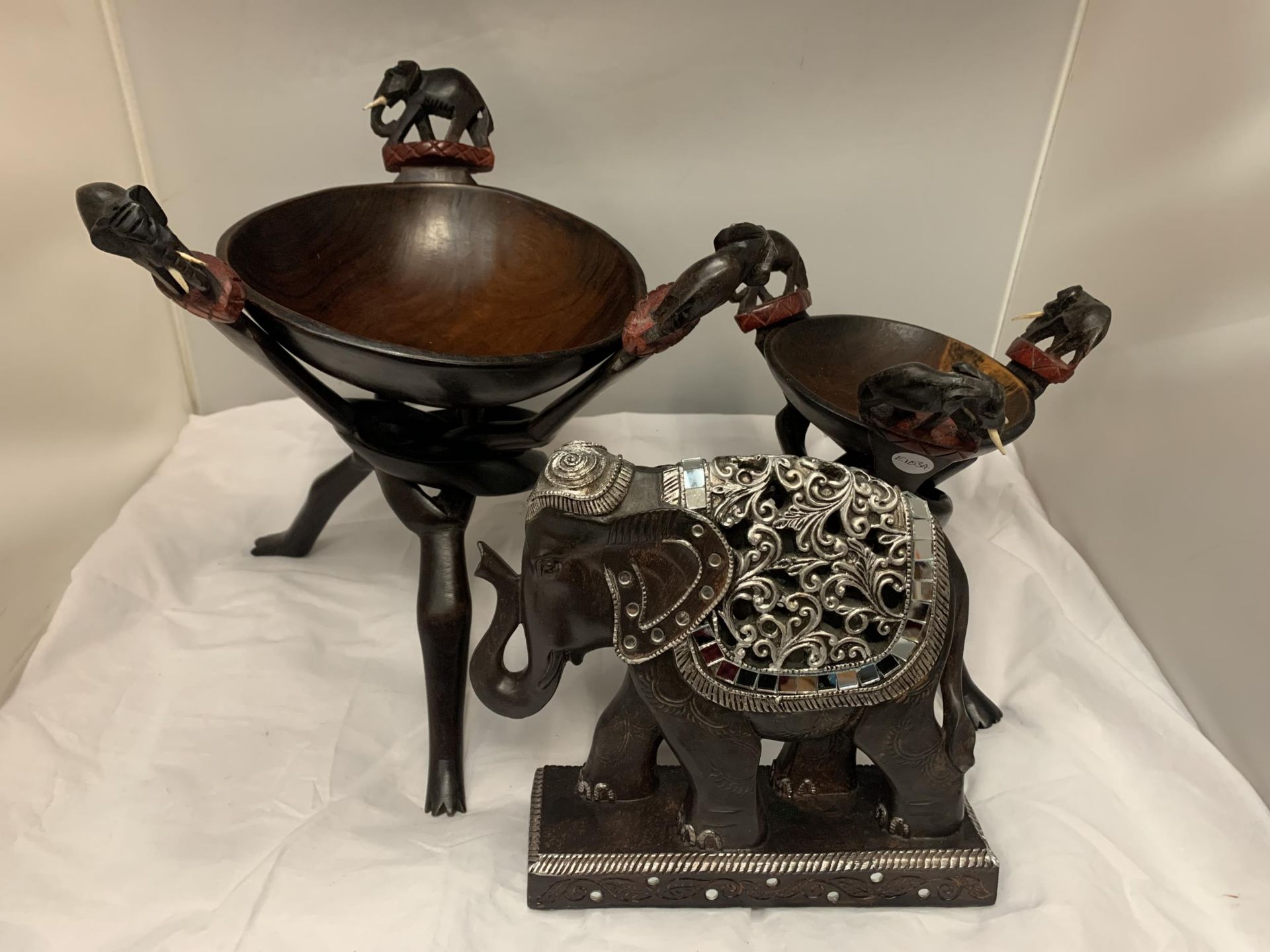 THREE ELEPHANT THEMED ITEMS TO INCLUDE TWO BOWLS ON TRIPOD LEGS AND A HIGHLY DECORATIVE WOODEN