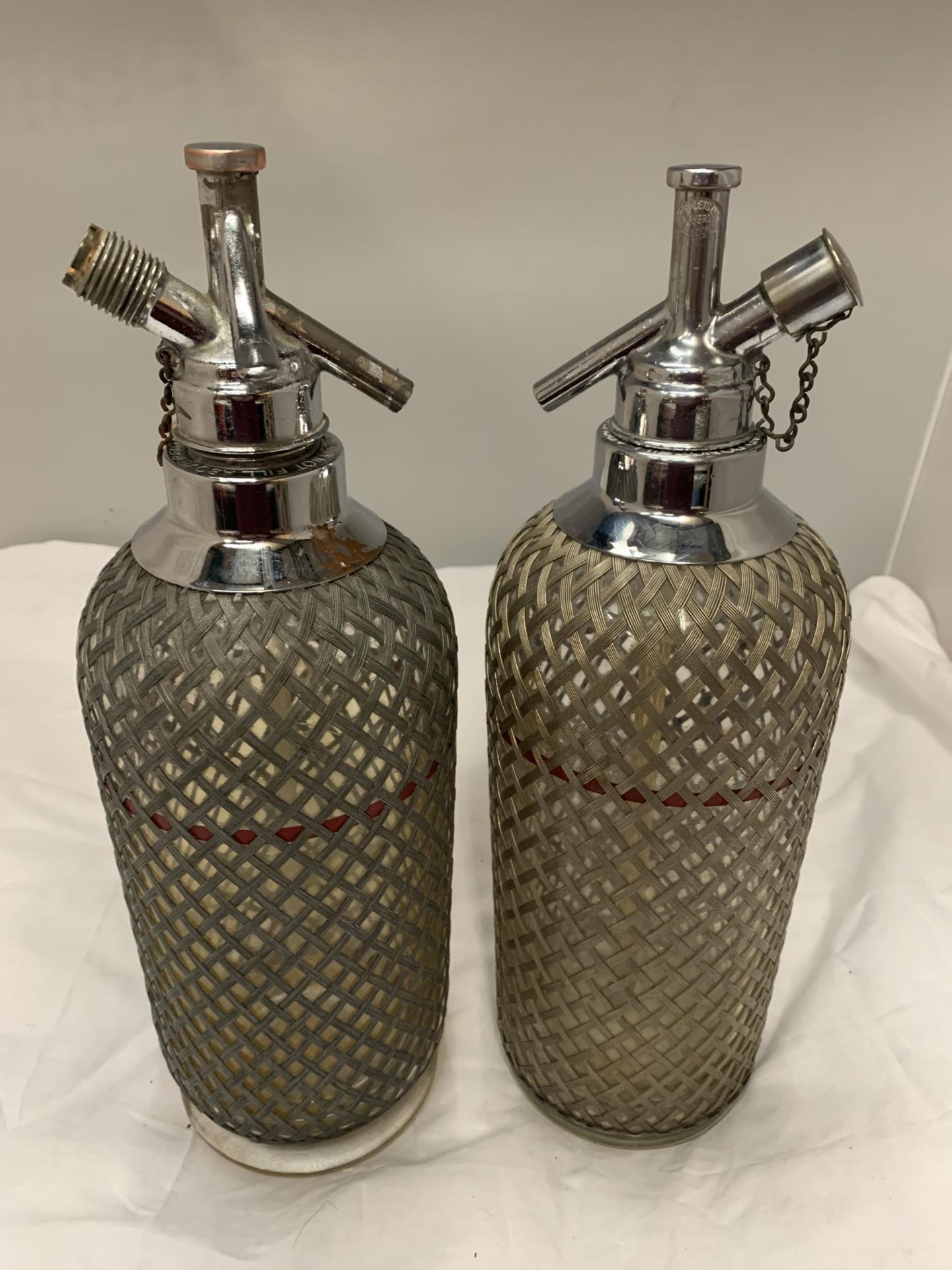 TWO SODA SYPHONS WITH WIRE STYLE MESH COVERING, MADE IN ENGLAND