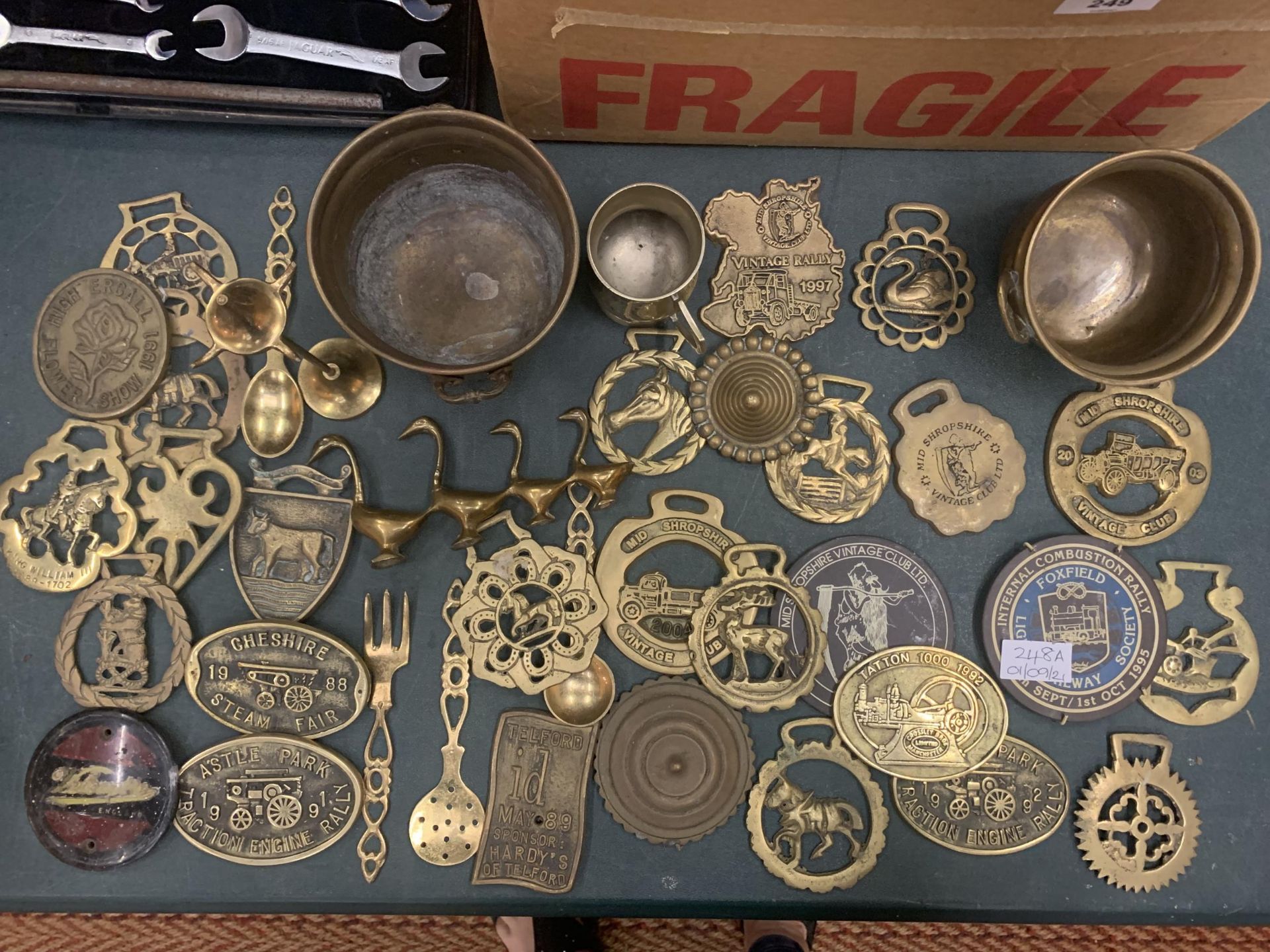 A ALRGE COLLECTION OF BRASS ITEMS TO INCLUDE HORSE BRASSES, STEAM FAIR BADGES, DISHES ETC