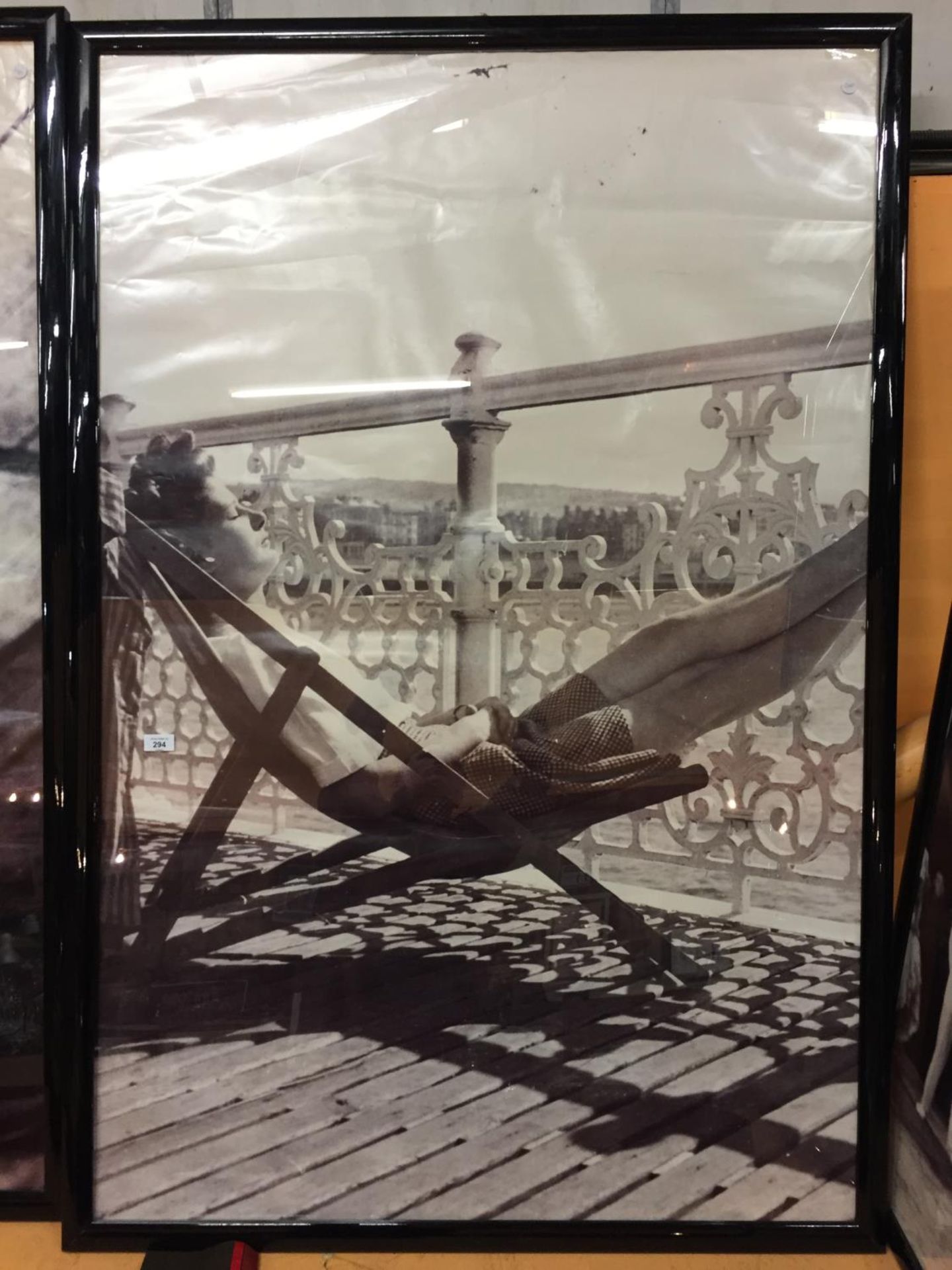 A VERY LARGE KODAK BLACK AND WHITE FRAMED 1940'S/1950'S PRINT OF A LADY SUNNING HERSELF ON THE