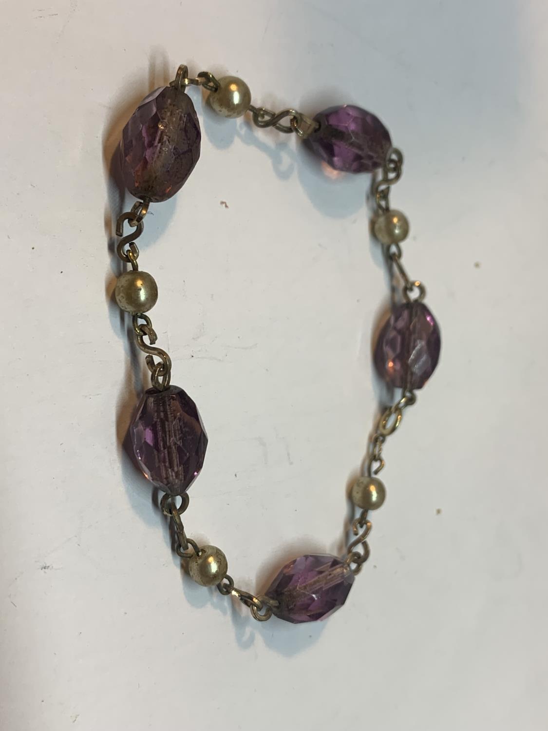 A 9 CARAT GOLD WIRE AND AMETHYST BRACELET IN A PRESENTATION BOX