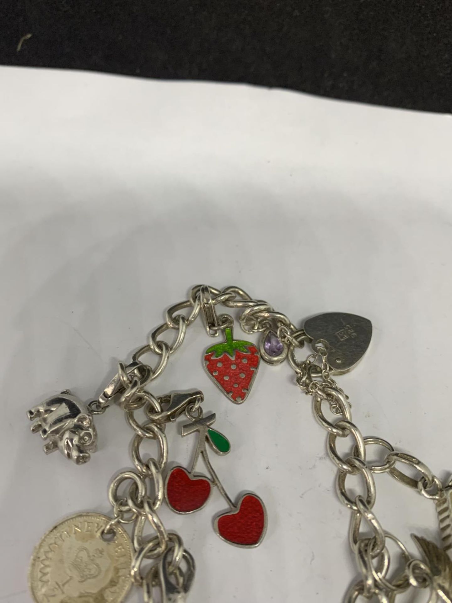 A HEAVY SILVER CHARM BRACELET WITH THIRTEEN CHARMS TO INCLUDE A STRAWBERRY, CHERRIES, DOVE ETC - Image 3 of 4