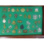A GLAZED DISPLAY CASE CONTAINING THIRTY EIGHT BRITISH ARMY CAP BADGES, 33CM X 48CM