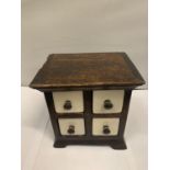 A MINATURE WOODEN CHEST WITH FOUR GLAZED CERAMIC DRAWERS