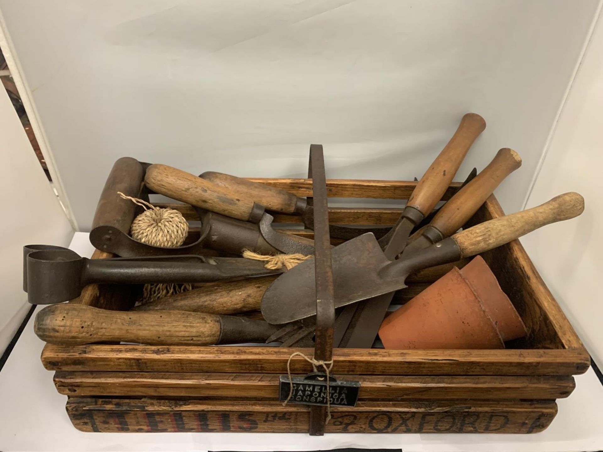 A VINTAGE GARDEN TRUG WITH VARIOUS TOOLS TO INCLUDE TROWEL, FORK, SYTHE, DIBBER, TERRACOTTA POTS ETC