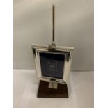 A SILVER PLATED PHOTO FRAME 3.5'' X 5'' ON A WOODEN ADJUSTABLE STAND