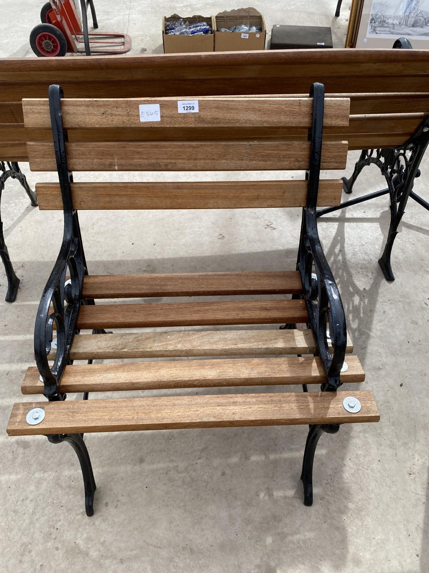 A WOODEN SLATTED GARDEN CHAIR WITH CAST IRON ENDS