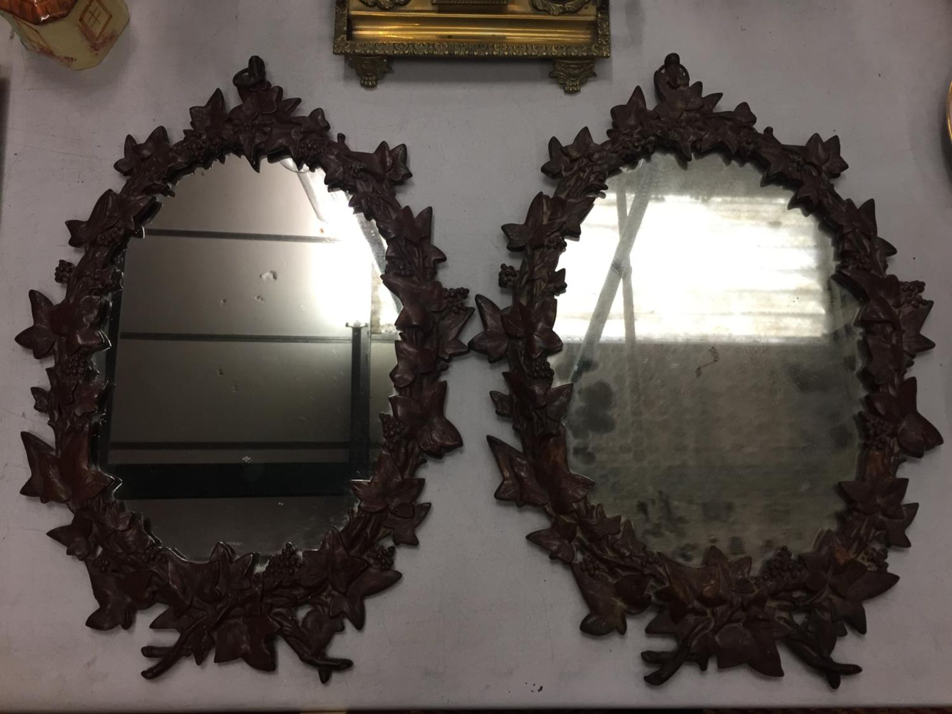 A PAIR OF HEAVY MATCHING WALL MIRRORS WITH ORNATE LEAF DESIGN