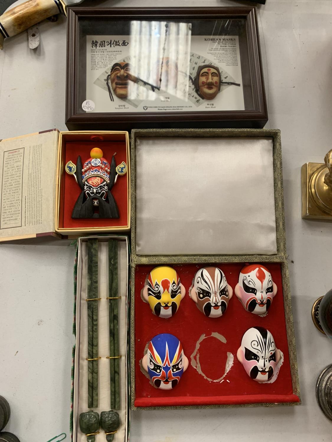 A COLLECTION OF ORIENTAL MASKS AND BOXED CHOPSTICKS ETC