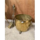 A LARGE DECORATIVE BRASS COAL BUCKET WITH LION HEAD HANDLES AND CLAM FEET, TO ALSO INCLUDE FIRE SIDE