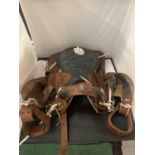 A TAN AND BLACK LEATHER U.S.A. WESTERN SADDLE WITH DECORATIVE DESIGNS AND STITCHING TOGETHER WITH