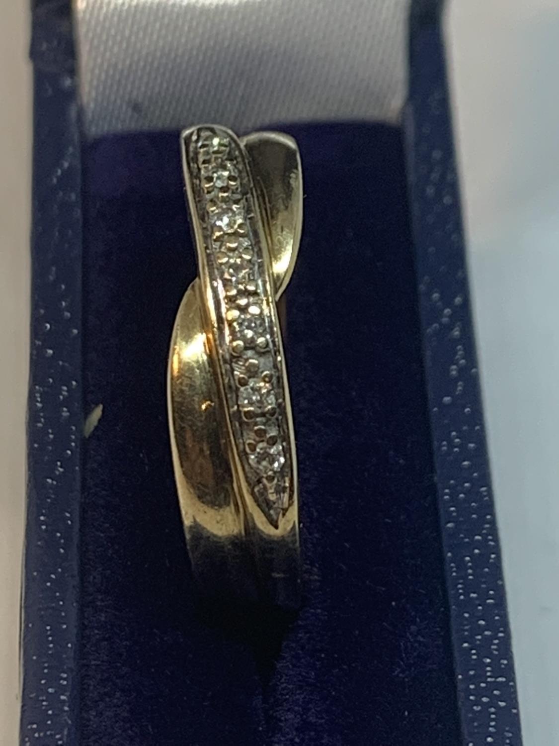 A 9 CARAT GOLD TWIST RING WITH IN LINE DIAMONDS IN A PRESENTATION BOX